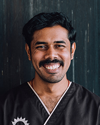 naturhotel_chesa_valisa_dr.dinu_spa_lächeln_gerader_blick_nah_holzwand Online.jpg